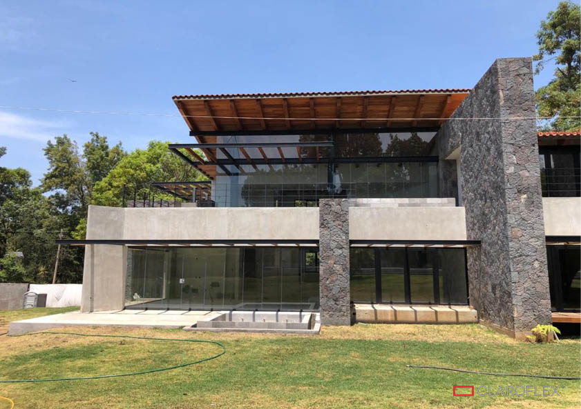 Residencia tipo rústico moderno con balcones y terrazas protegidos con cortina de cristal